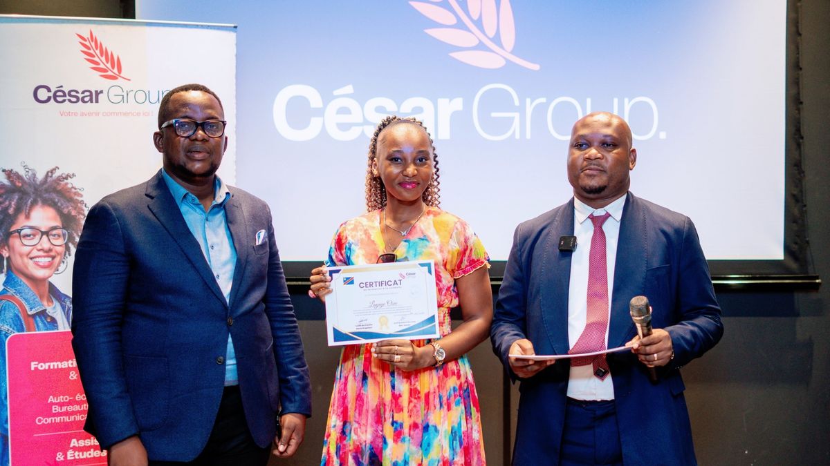 Une apprenante en robe colorée présente son certificat de formation lors de la cérémonie de remise